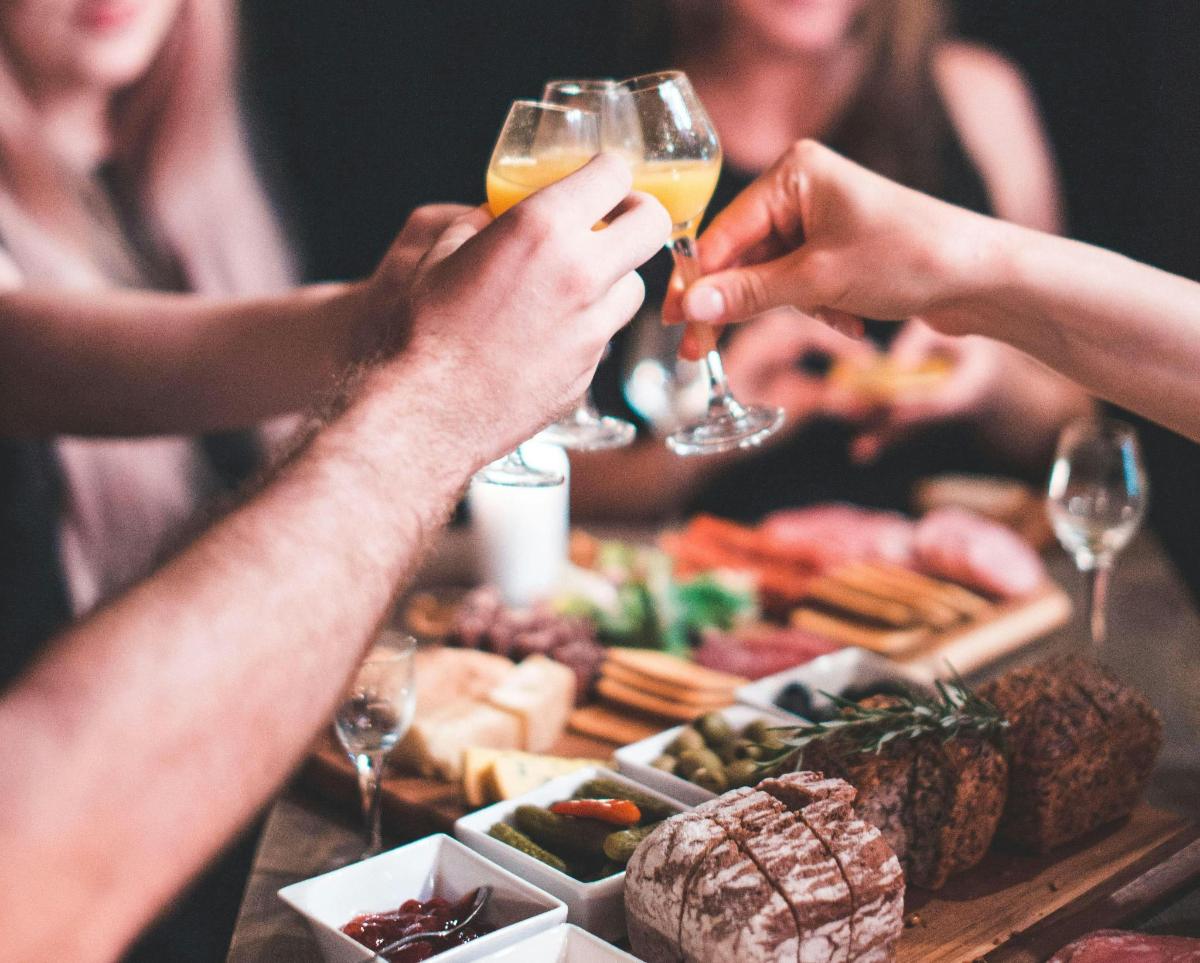 a group of people drinking wine at a table with food