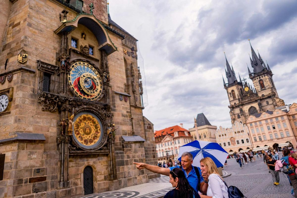 skupina lidí stojících před hodinovou věží