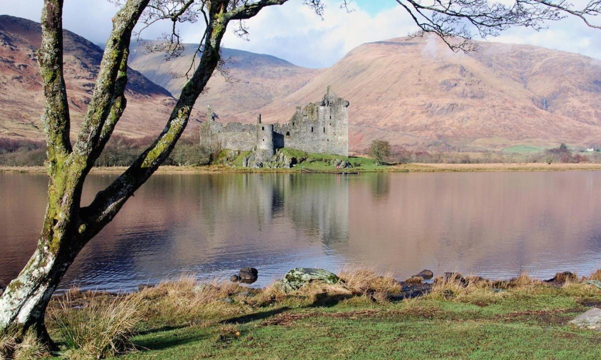 a castle in the middle of a lake with a mountain