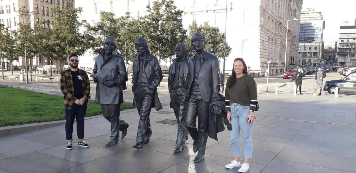 egy csoport ember áll egy szobor előtt