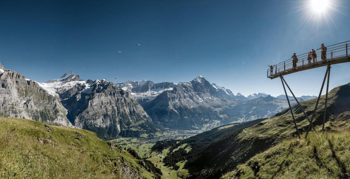 people on a suspension bridge over a mountain valley