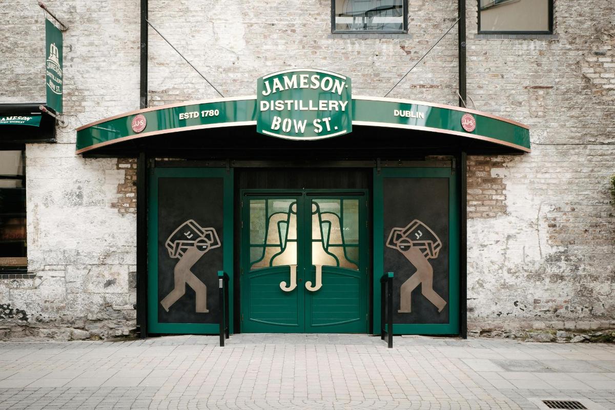a green door on a building with a sign above it
