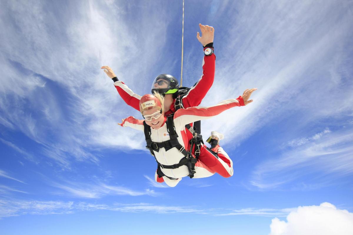 two people are jumping in the air in the sky