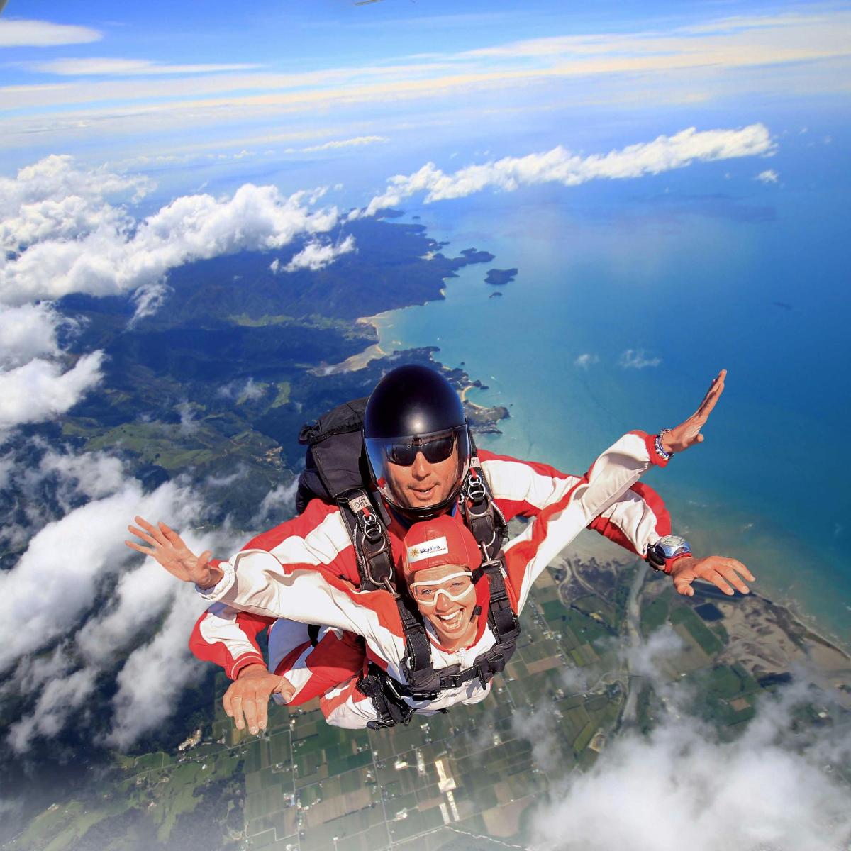 two people are floating in the sky over the clouds