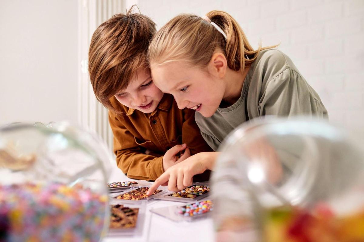 two girls are looking at a table with donuts