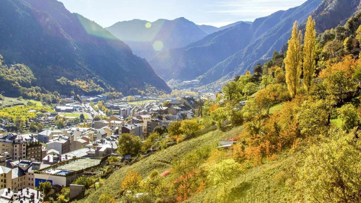 un pueblo en una colina con montañas al fondo