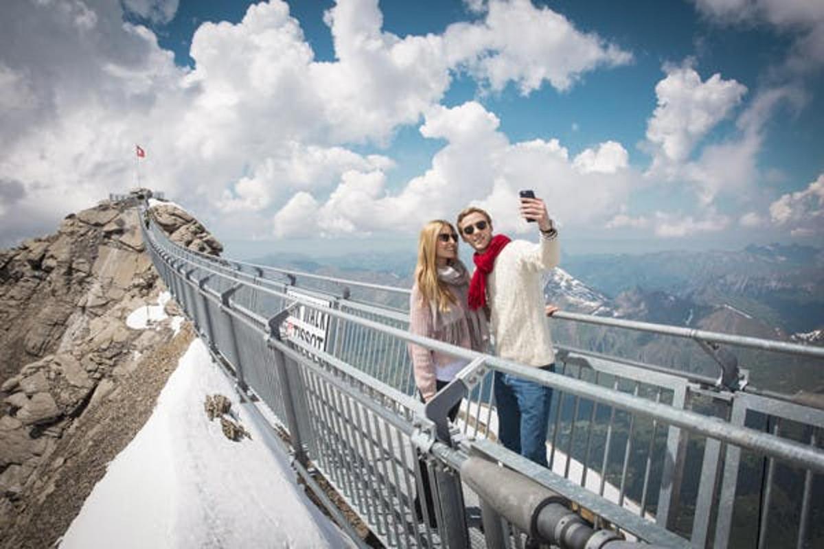 a man and woman taking a picture at the top of a mountain