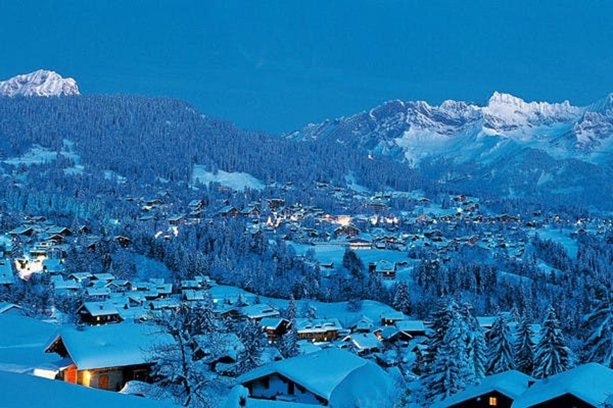 a town covered in snow with mountains in the background