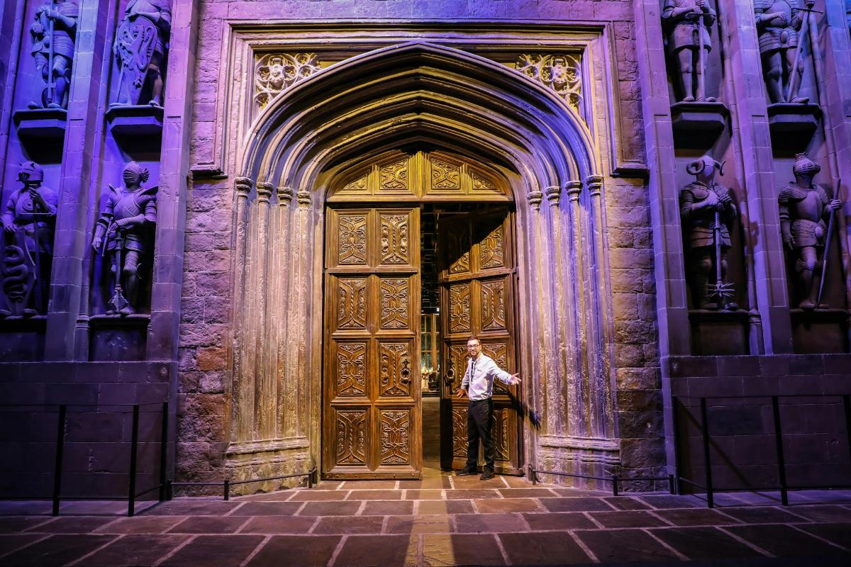 a man standing in front of a large wooden door