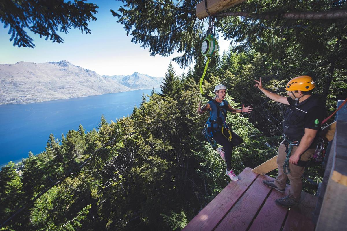 dva lidé na zip line nad jezerem