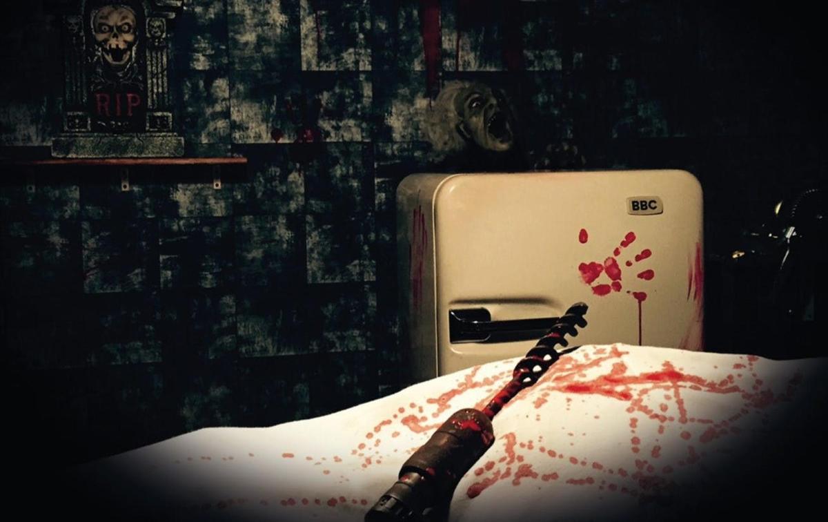 a bottle of wine sitting on a bed with blood