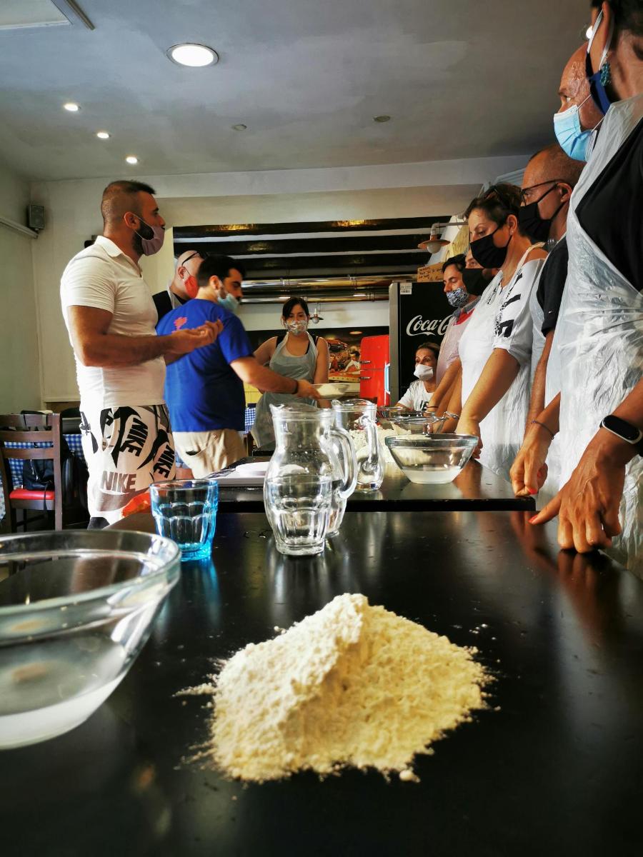 a group of people standing in a kitchen preparing food