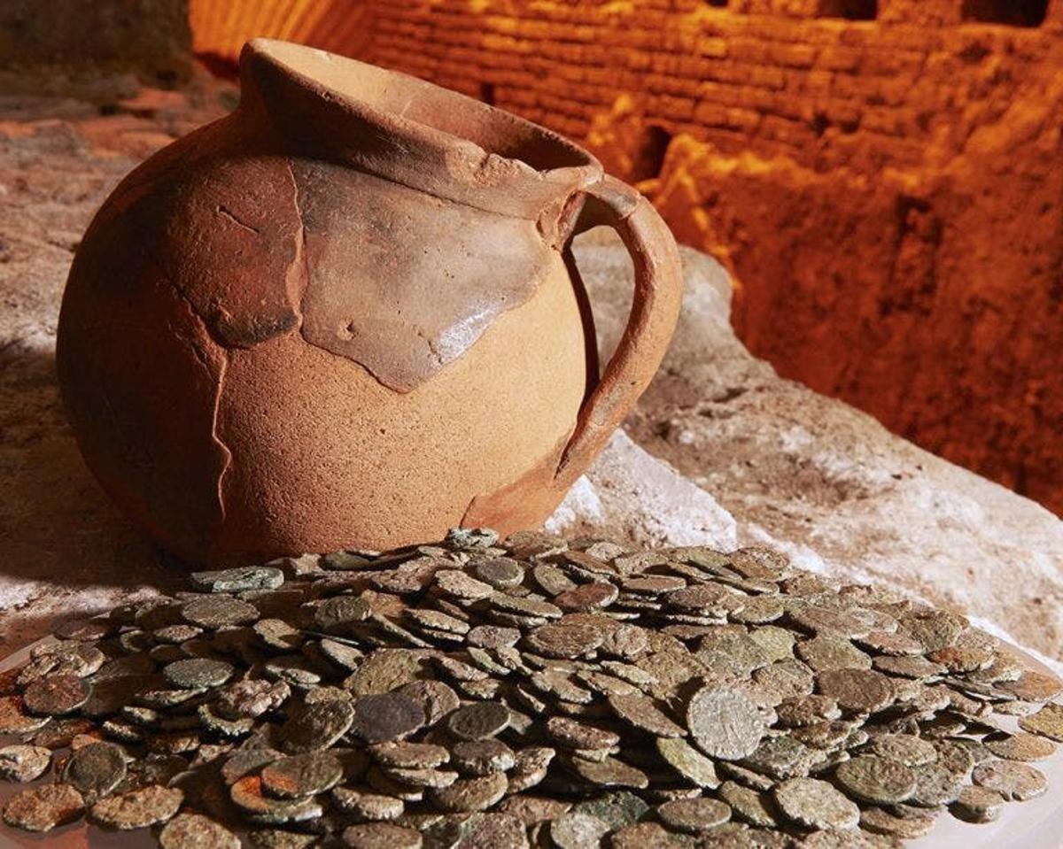 a pot sitting on top of a pile of coins