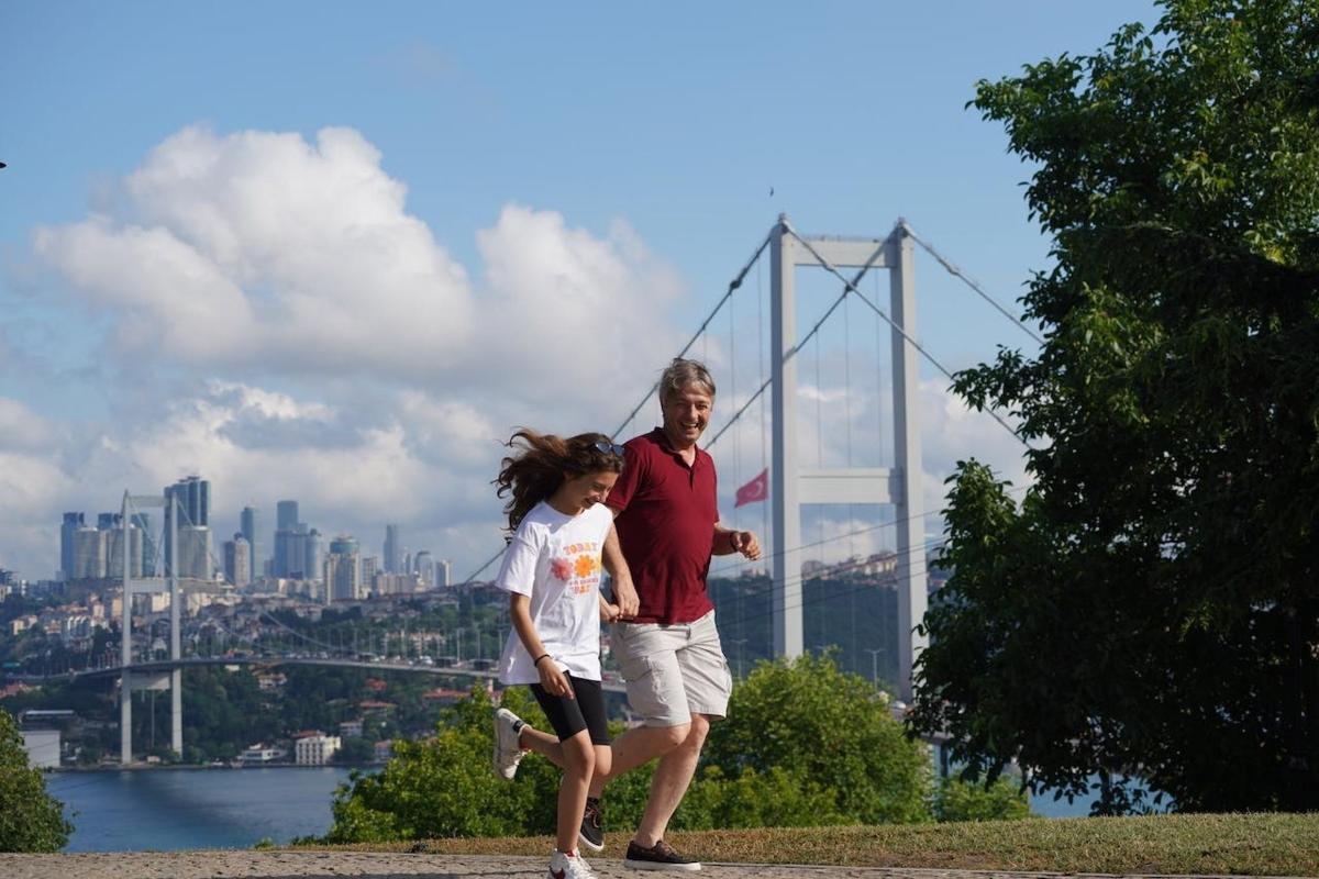 a man and a little girl running in front of a bridge