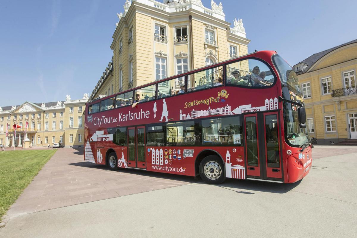 a red double decker bus parked in front of a building