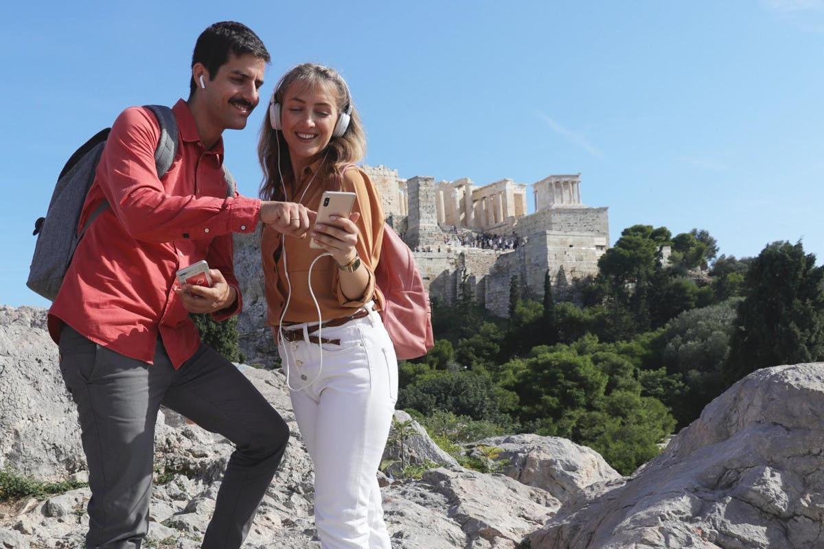 Un hombre y una mujer tomando una fotografía de la acrópolis.