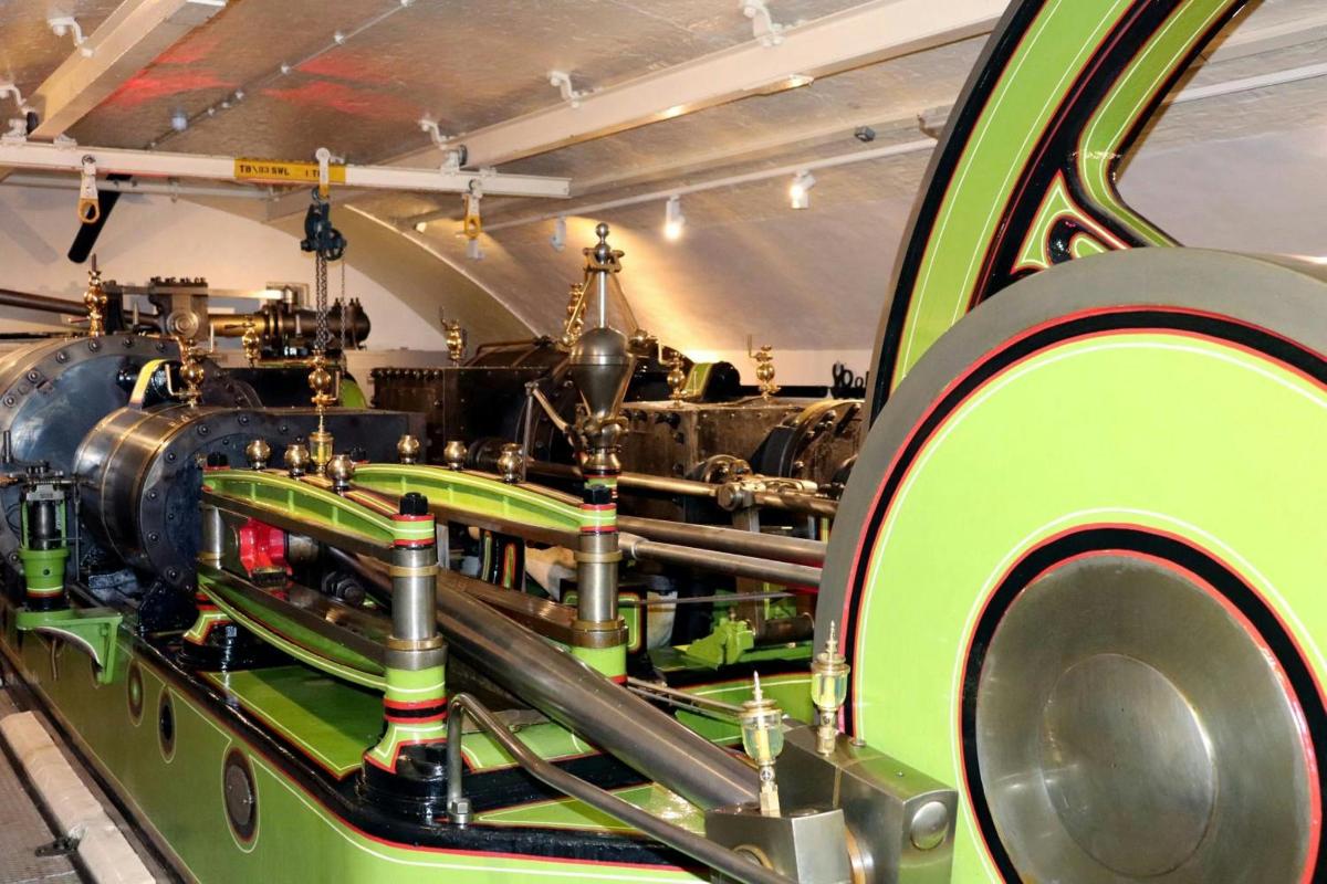 a green train engine on display in a museum