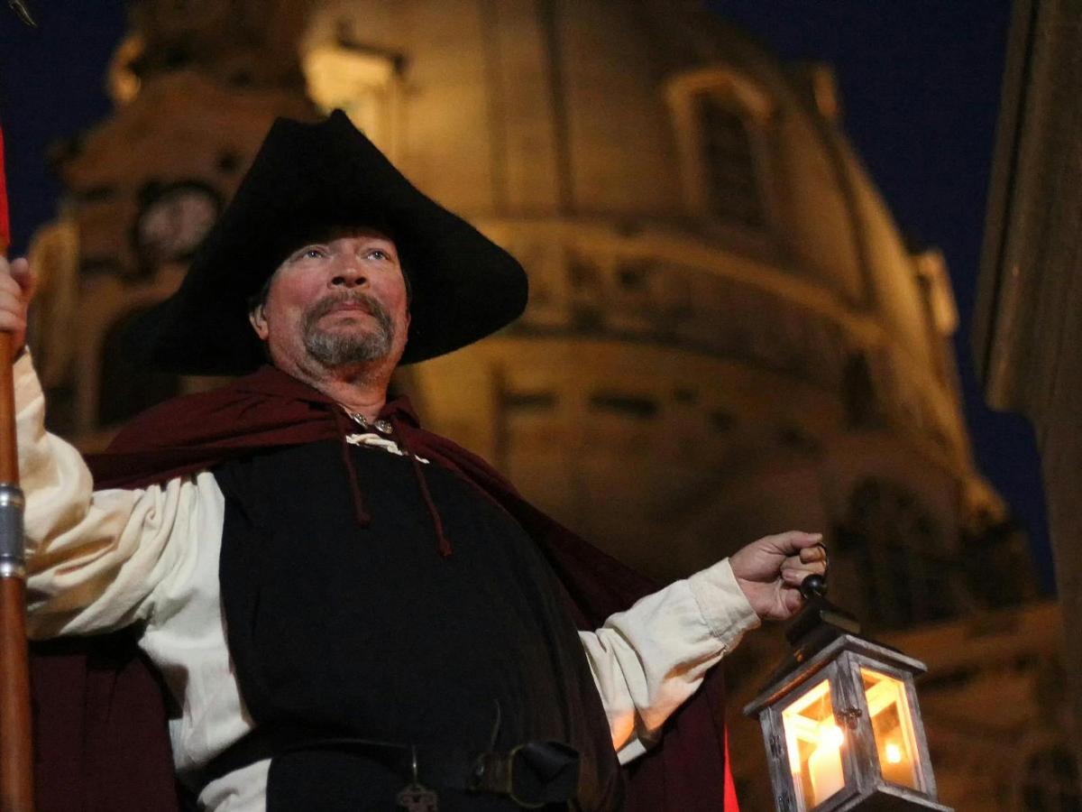 a man in a pirate costume holding a lantern