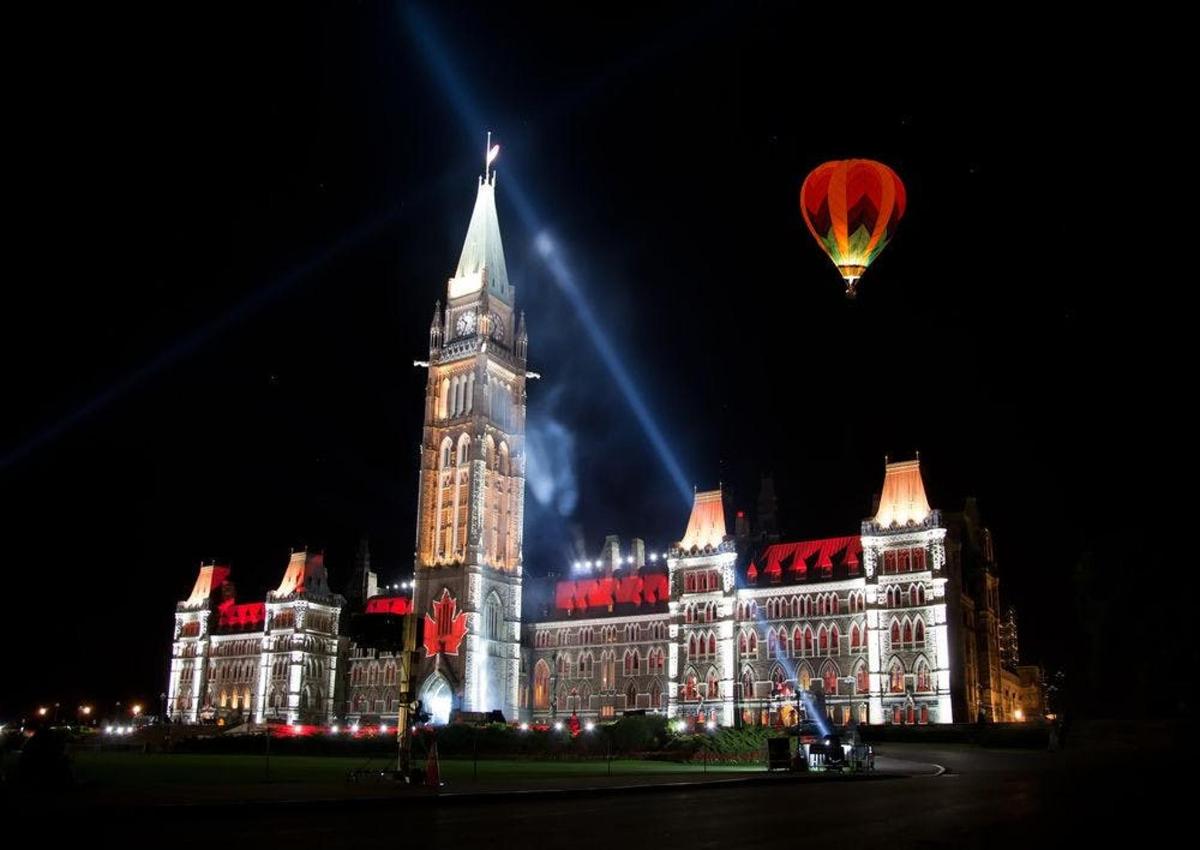 horkovzdušný balón letící nad budovou s hodinovou věží
