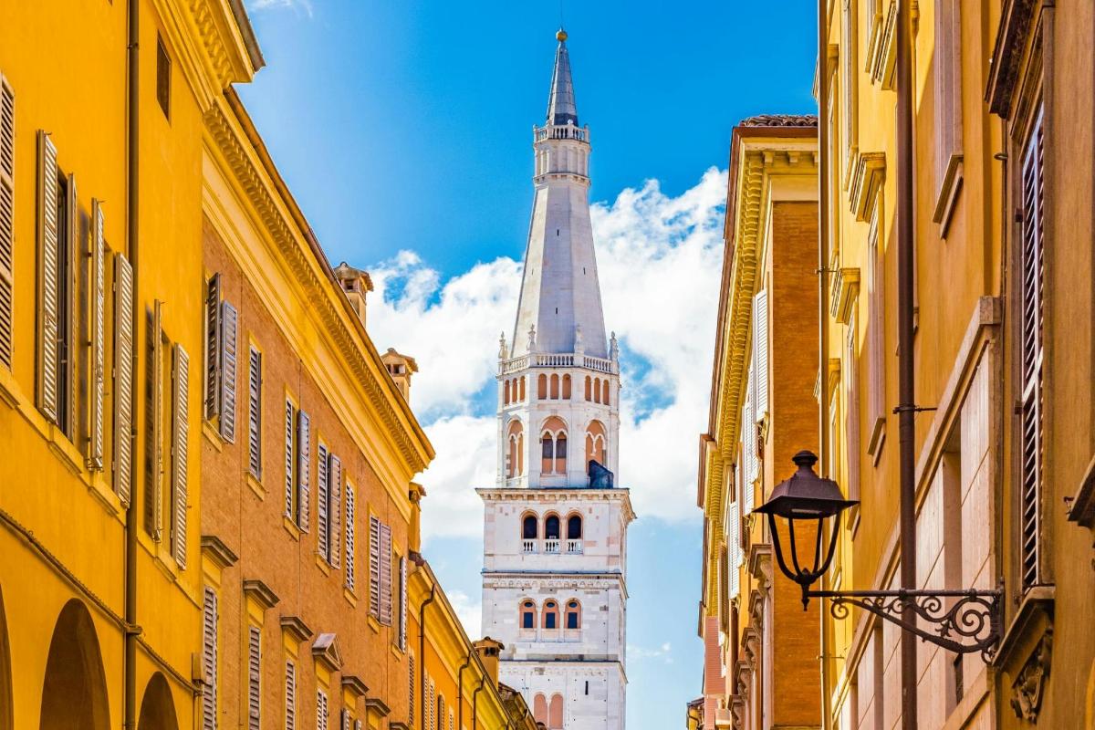una torre blanca i alta amb un campanar a la distància entre els edificis