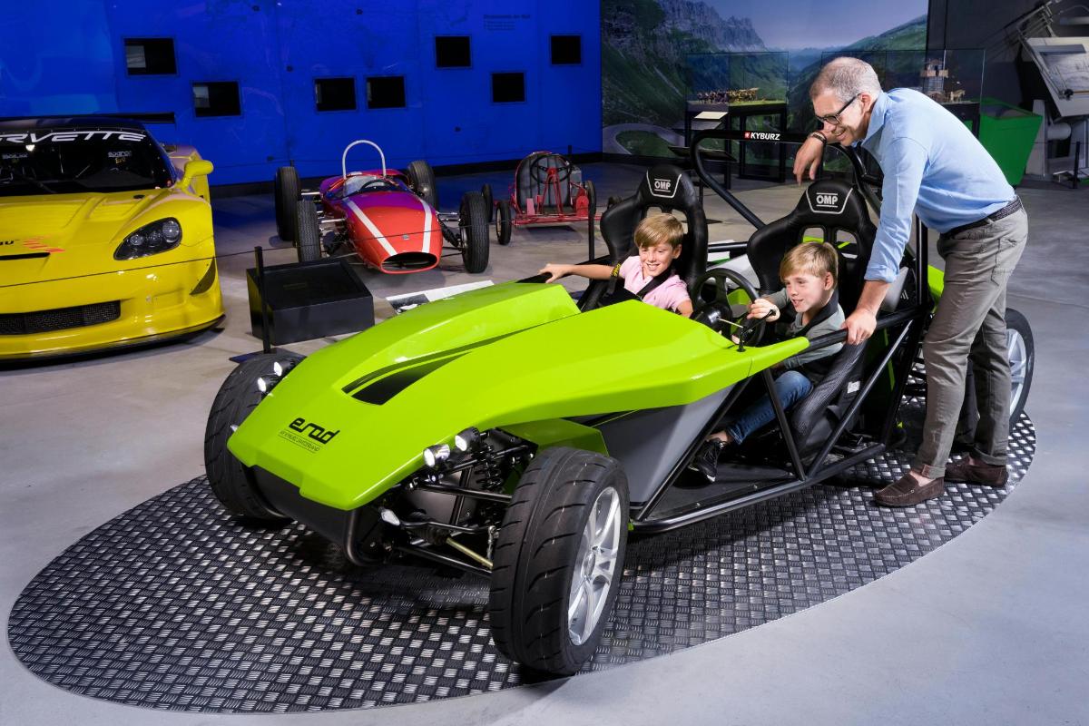 a man and two children in a green car