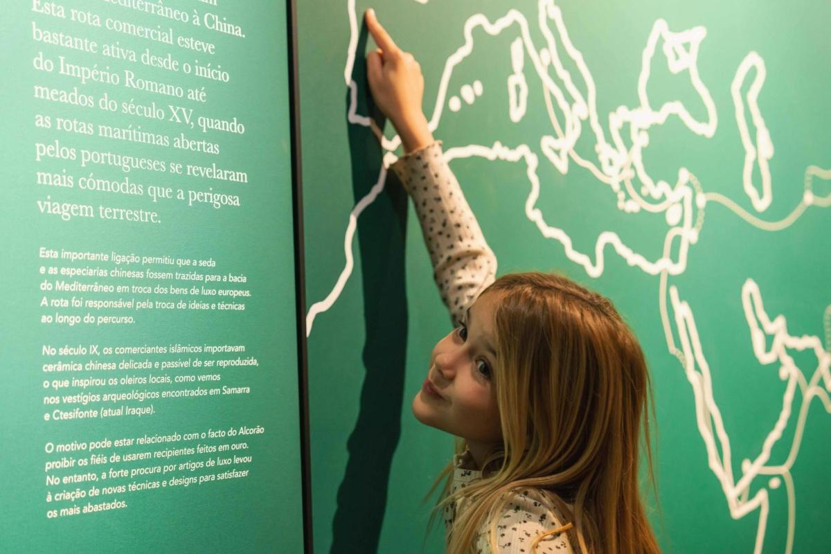una noia jove està dreta al costat d'un rètol