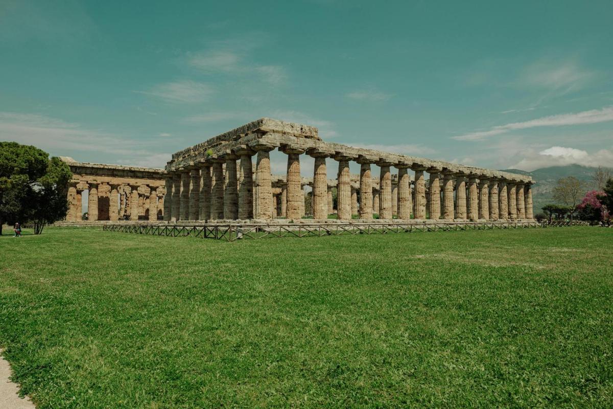 a large building with columns on a field of grass