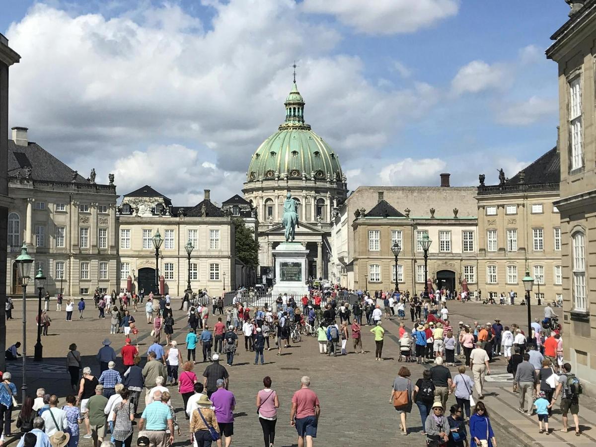 velká skupina lidí procházejících se kolem budovy