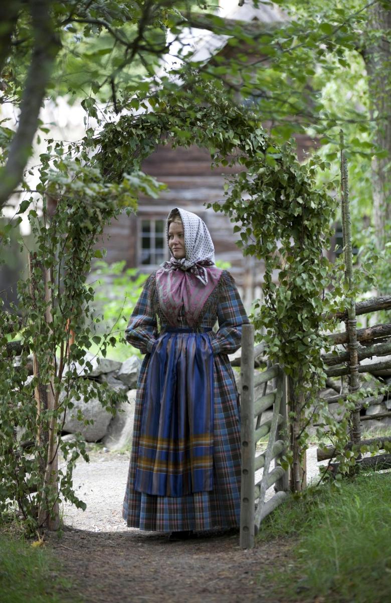 a woman in a dress standing under an arch