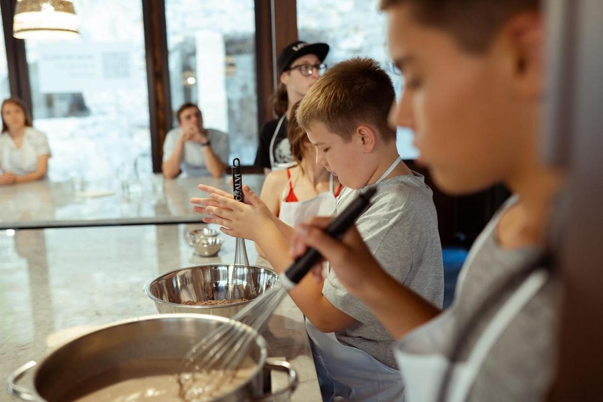 a group of people standing around a counter looking at their cell phones