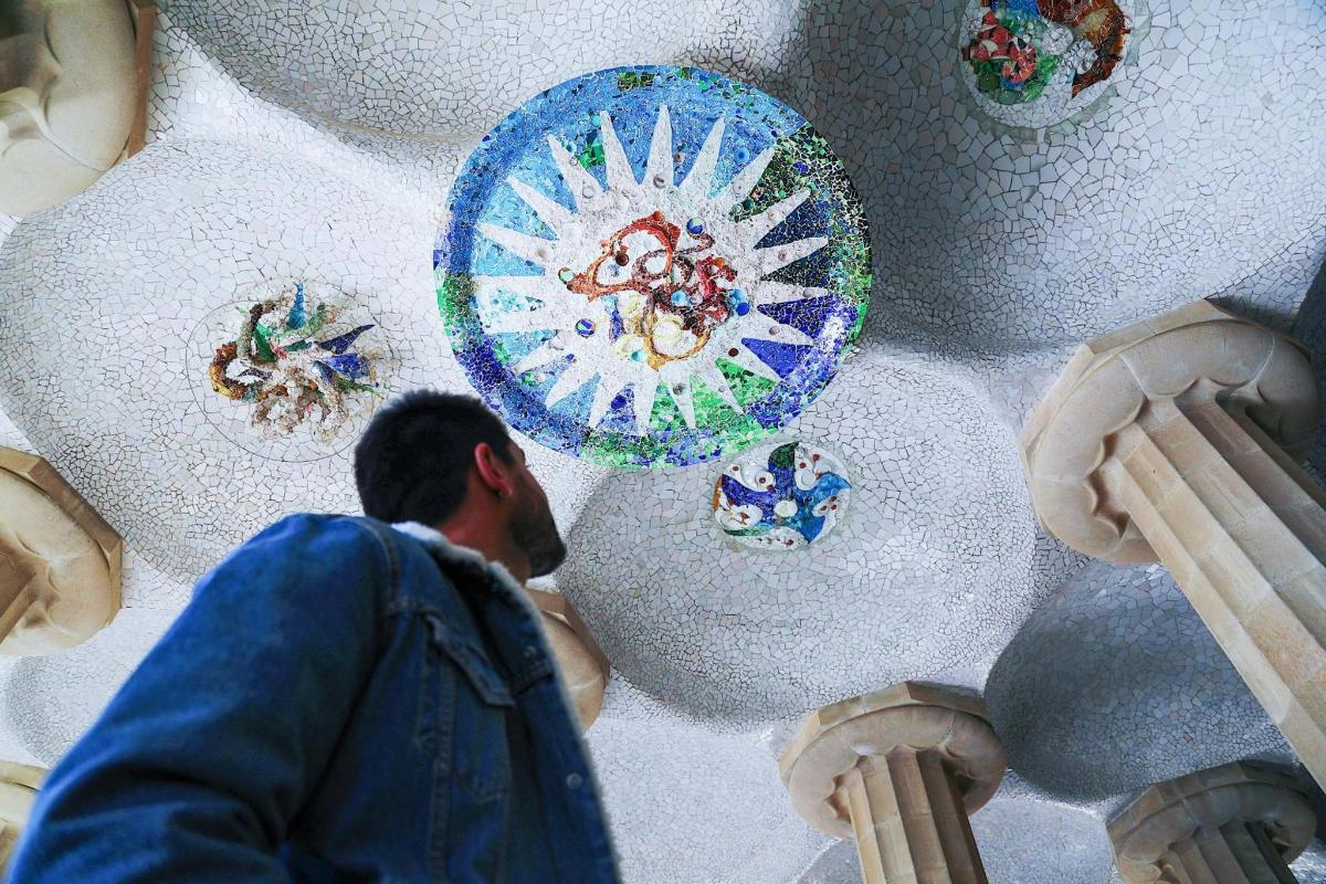 a man looking up at a wall with plates on it