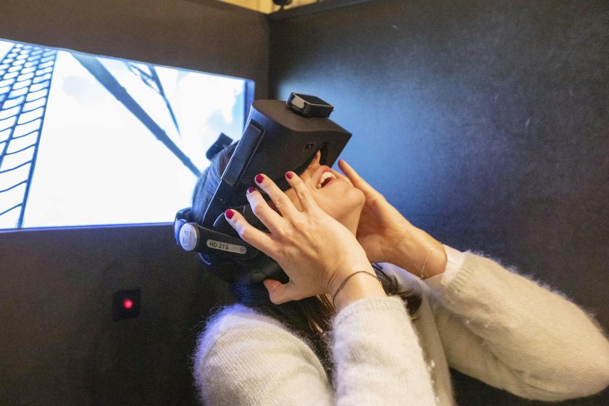 a woman is holding a camera in front of a television