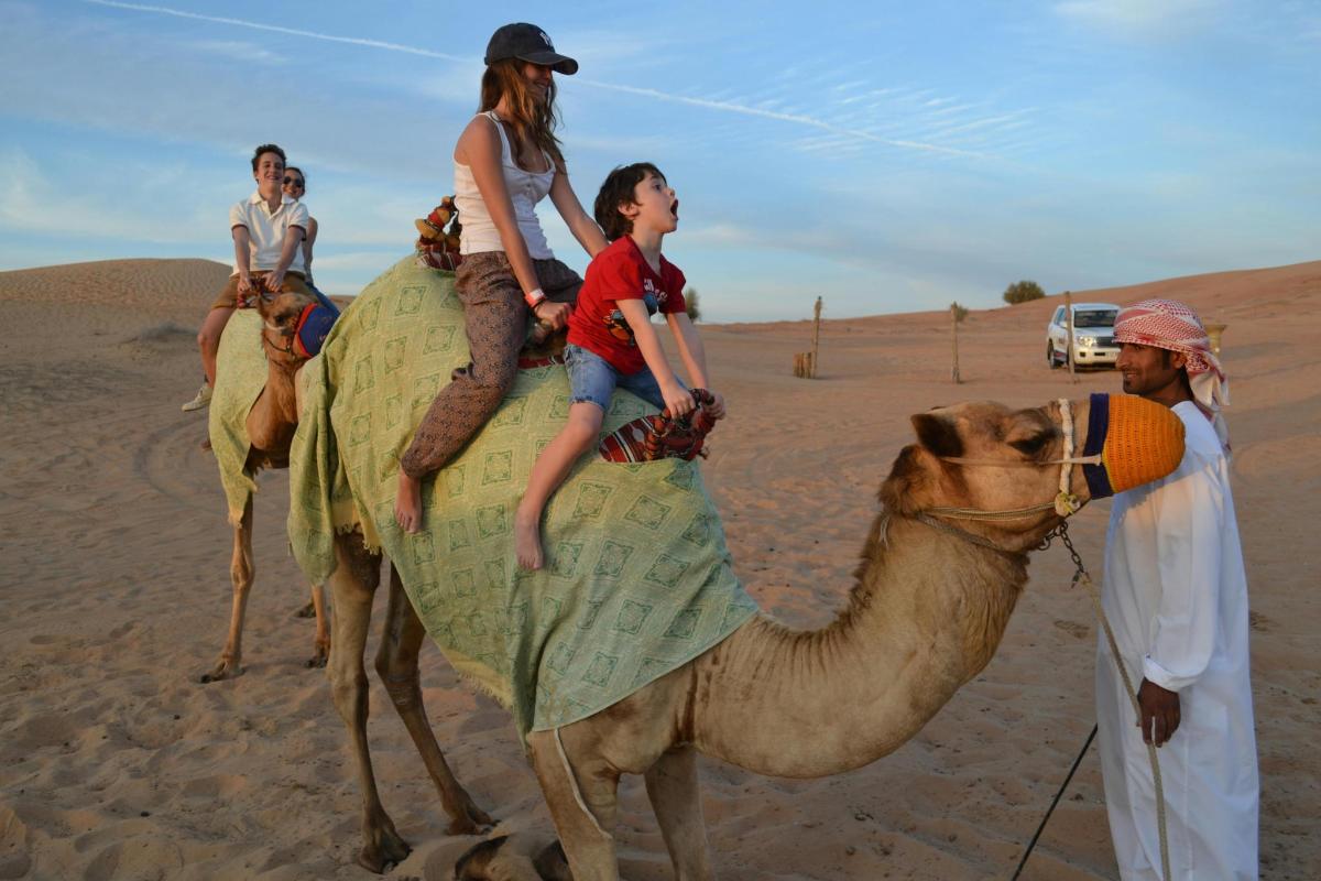 一群人骑着骆驼穿越沙漠