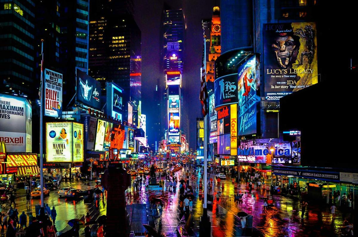 a busy city street at night with neon signs