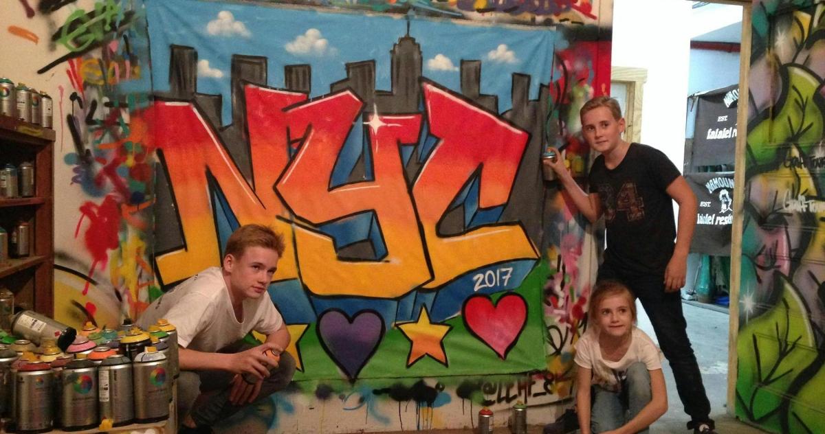 a family posing in front of a wall with graffiti