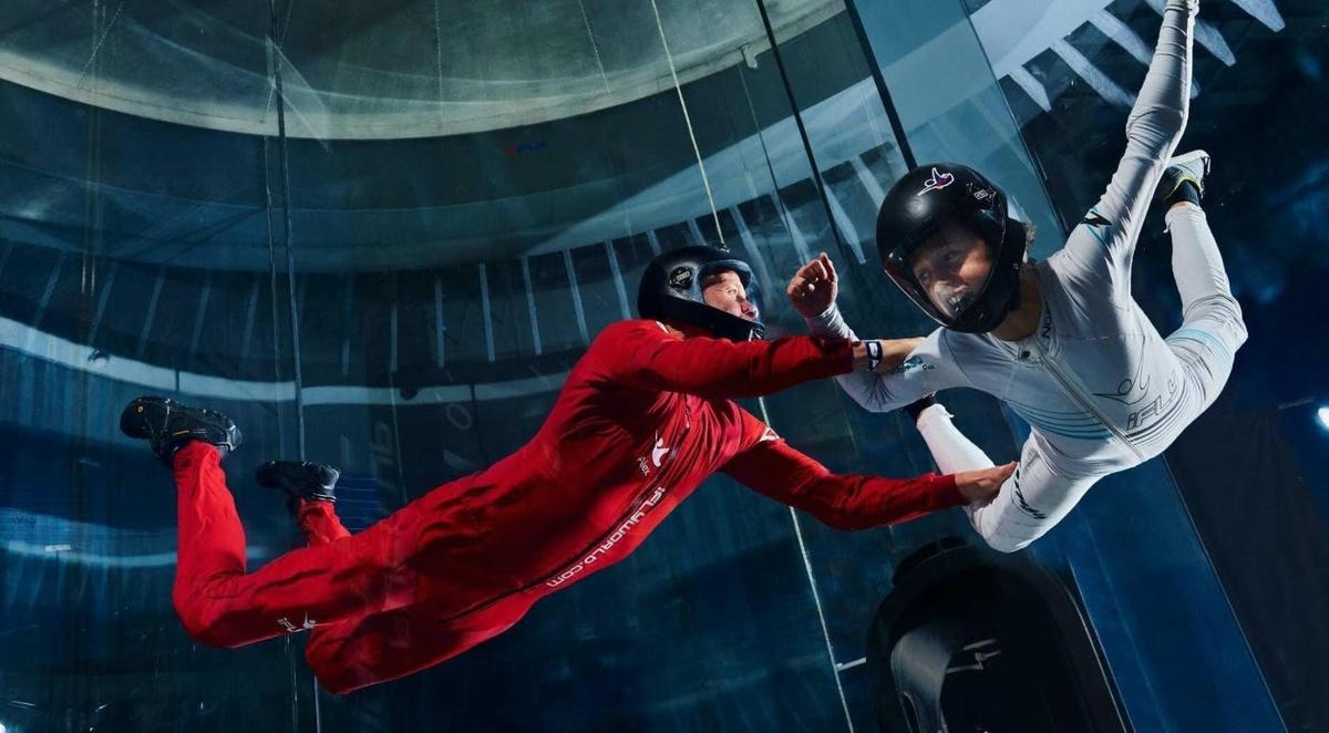 two people are climbing on a glass wall