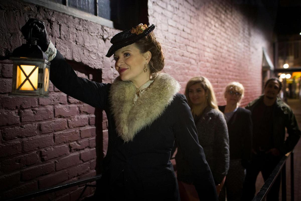 a woman standing next to a brick wall
