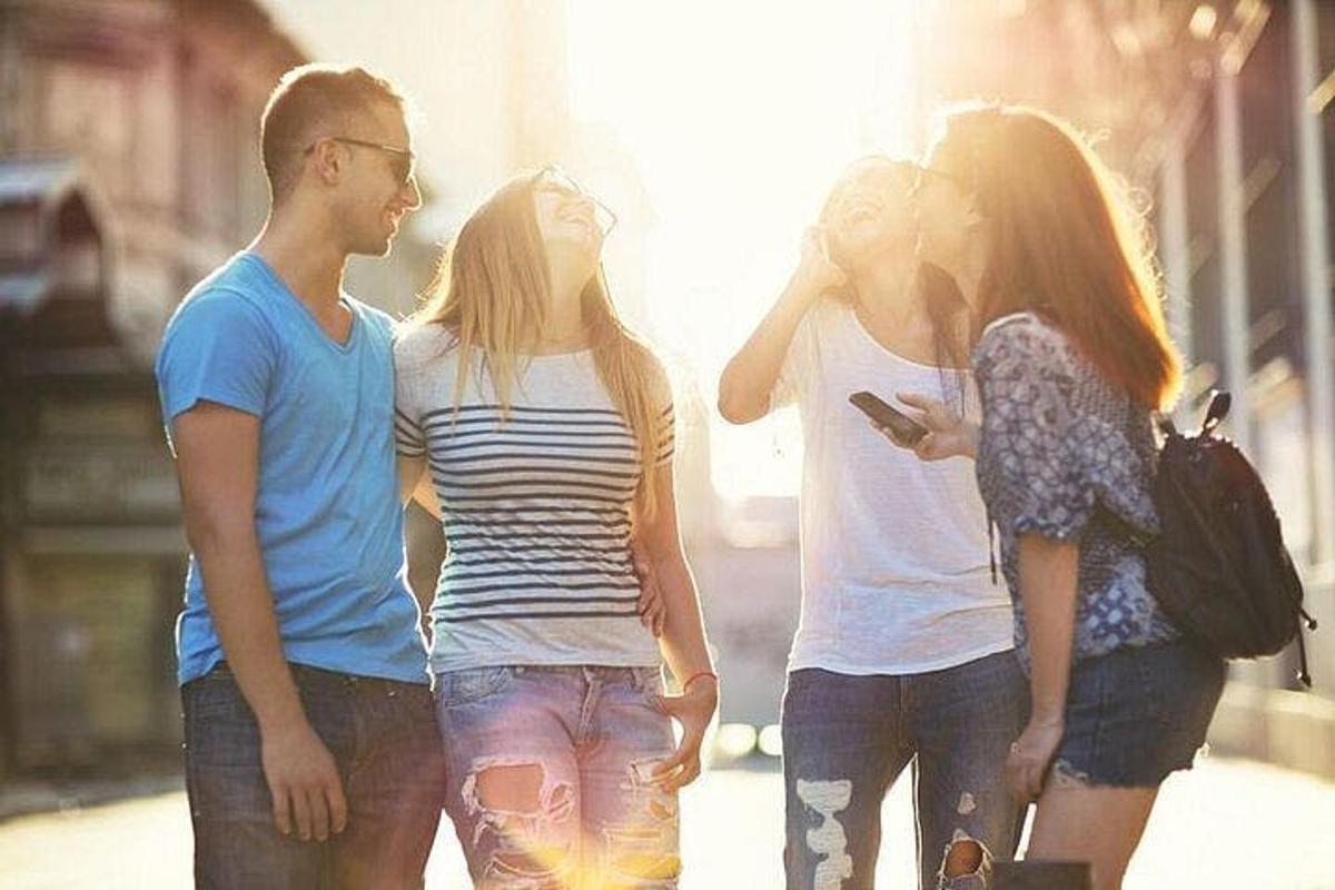 three young people walking down a street