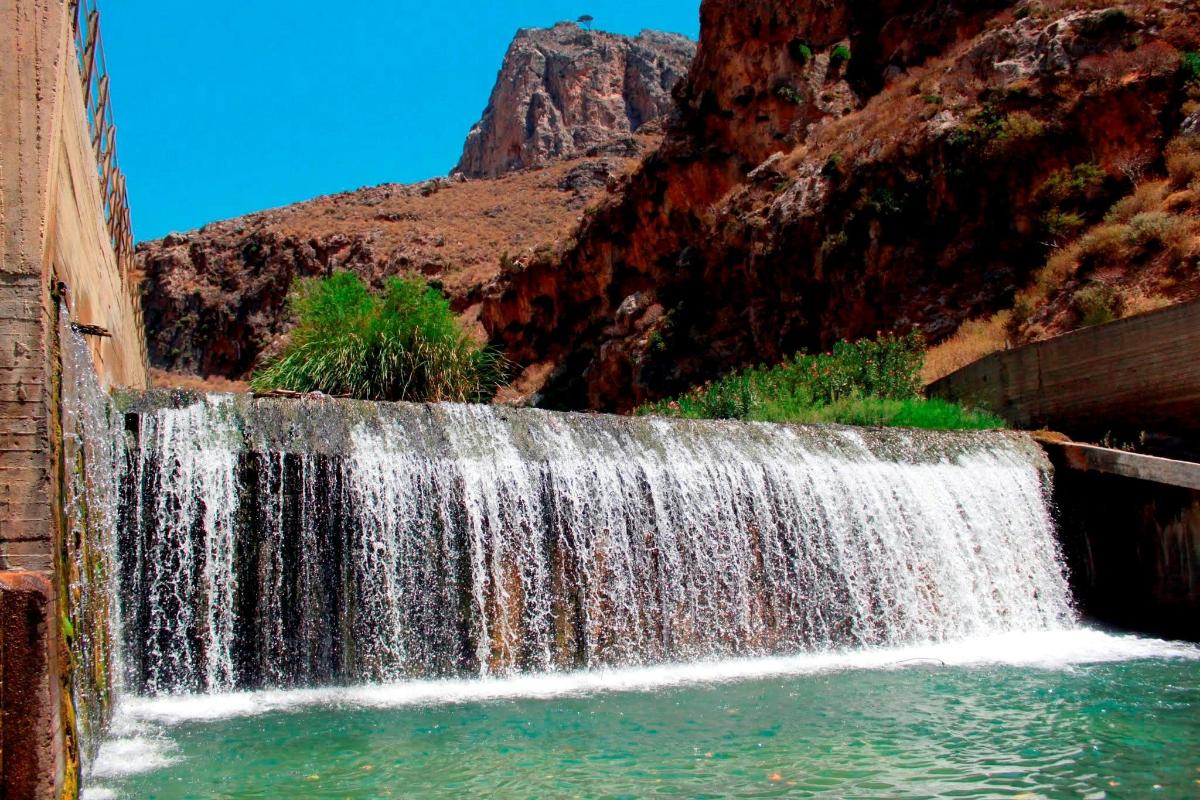una cascada en un cañón con una montaña al fondo