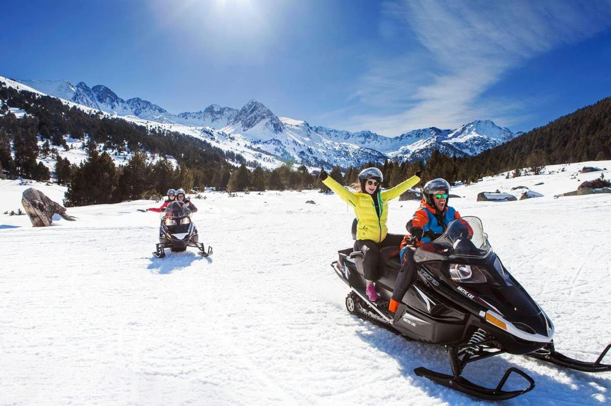 duas pessoas andando de snowmobile na neve