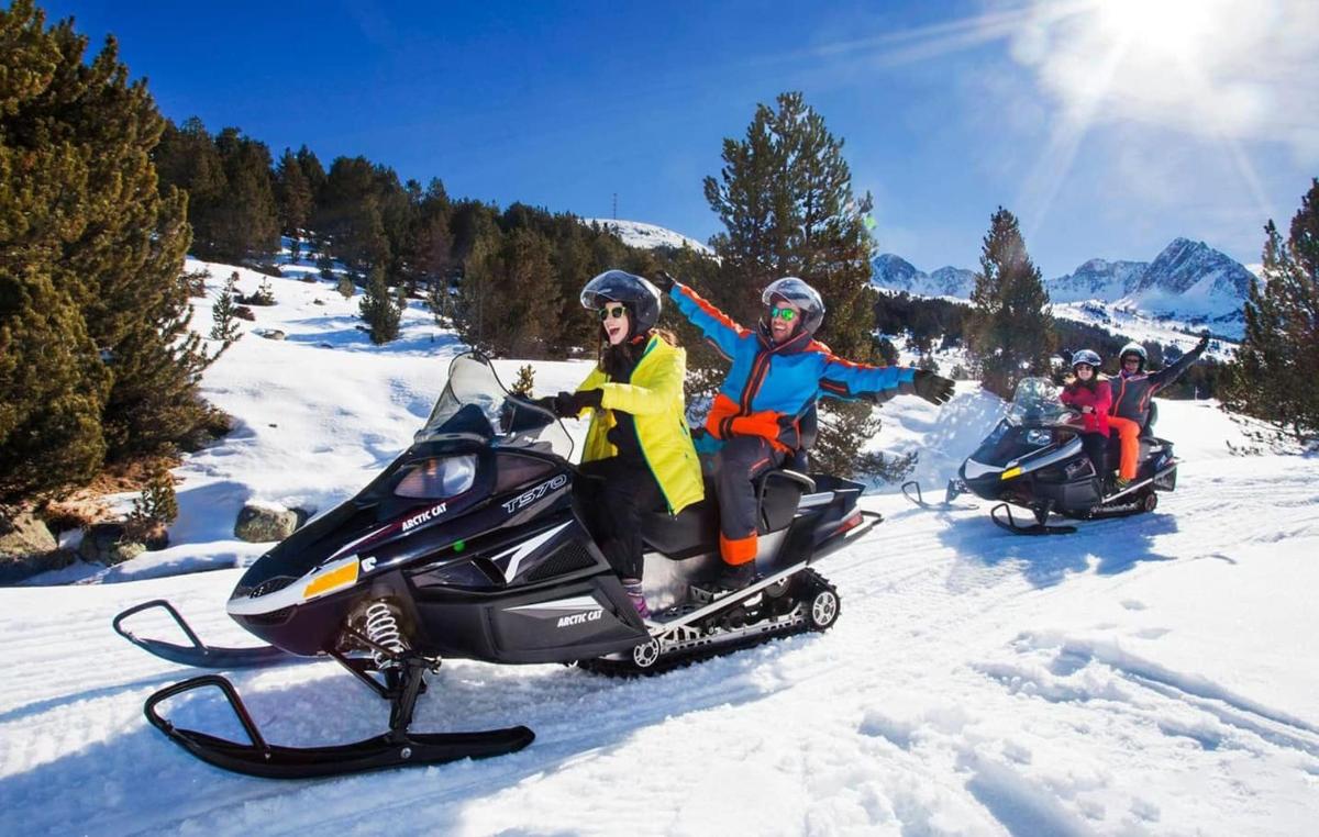 um grupo de pessoas andando de snowmobile na neve