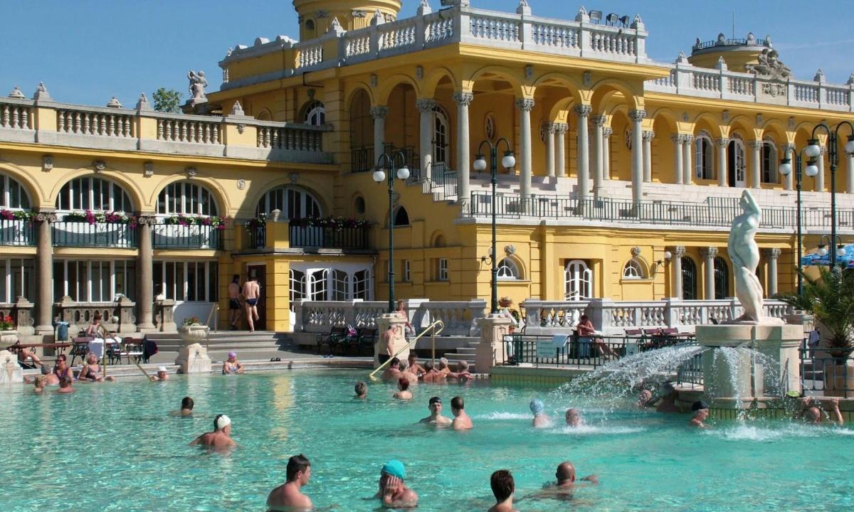 a group of people in a pool in front of a building