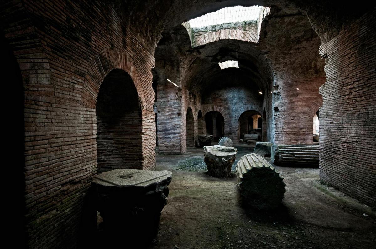 un vecchio edificio in mattoni con tavoli e panche al suo interno