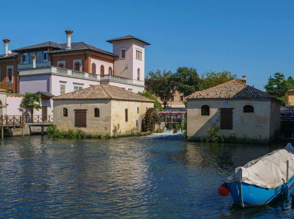 majhen čoln v vodi poleg stavb