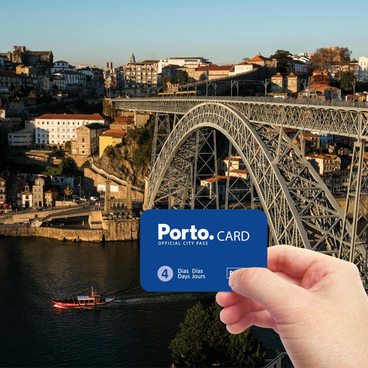 a hand holding a credit card in front of a bridge
