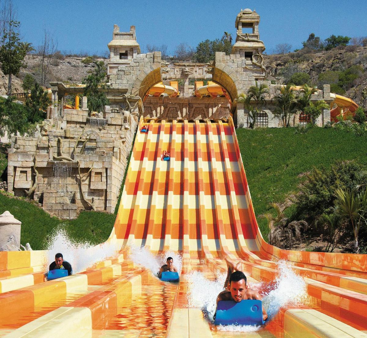 a group of people riding a water slide at a water park