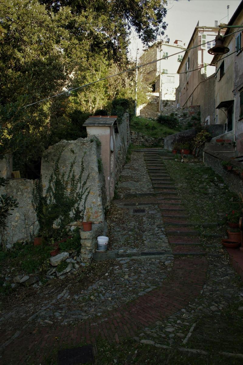 an alley with a stone wall and a stone path
