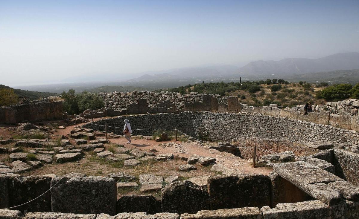 una persona in piedi in cima a delle rovine