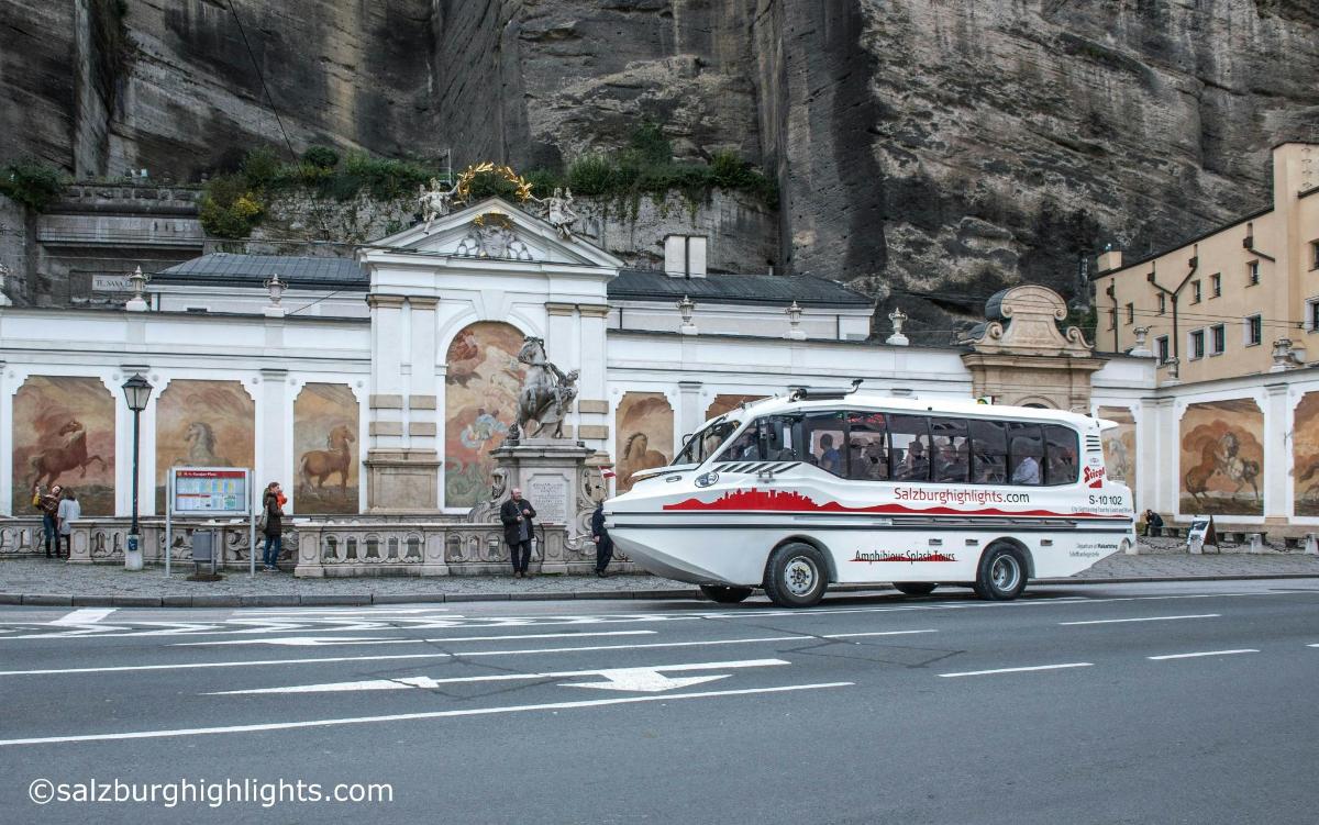 a white bus is parked in front of a building