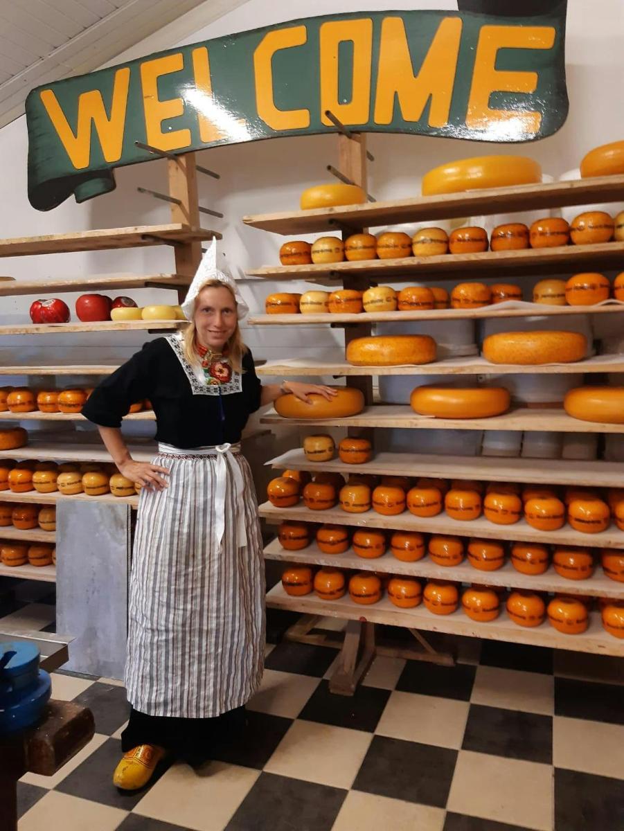 a woman standing in front of a display of donuts